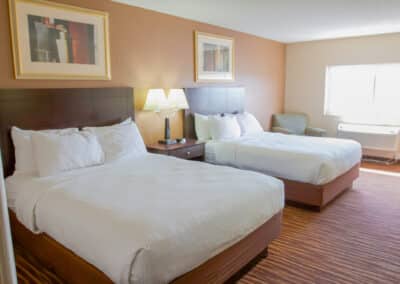 First Choice Inn's Queen's Room with 2 queen-sized bed, sofa and work table