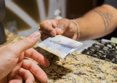 A man handing out an envelope with the room key inside to a customer