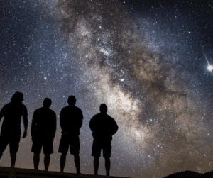 The silhouettes of four people staring at the night sky.